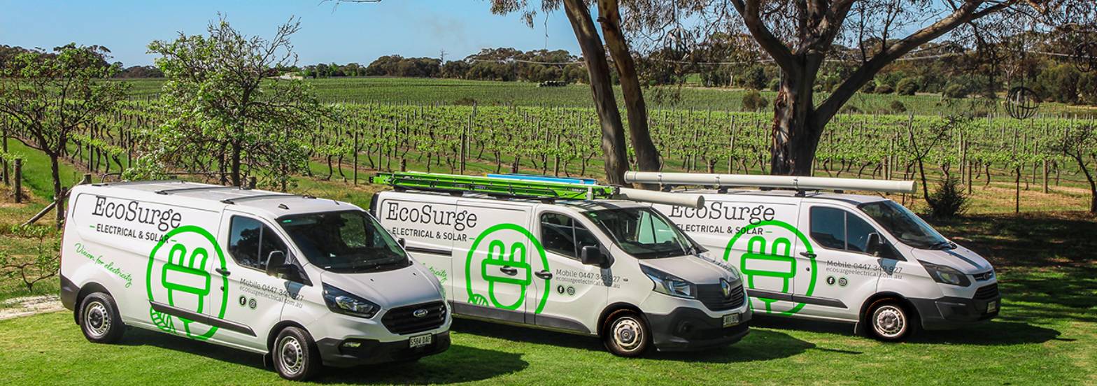 3 Ecosurge Electrical Vans parked on grass with gumtree and vineyard in background